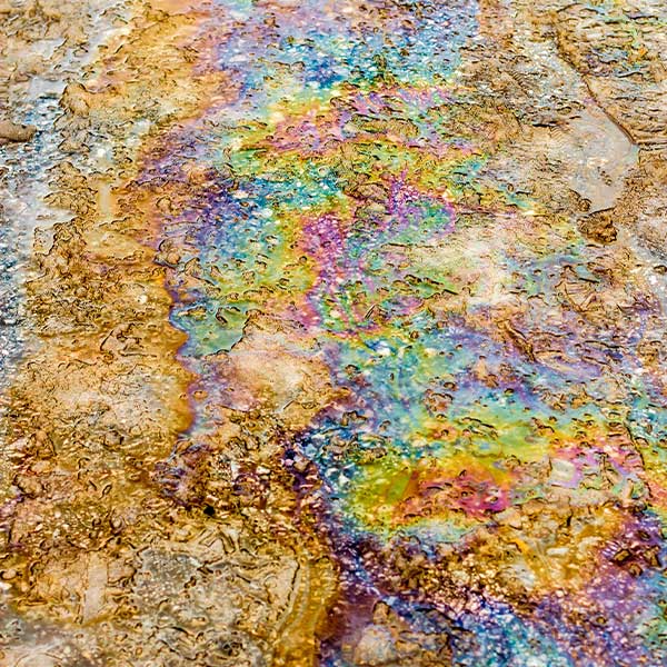 Eine raue Oberfläche schimmert in vielen Regenbogenfarben.